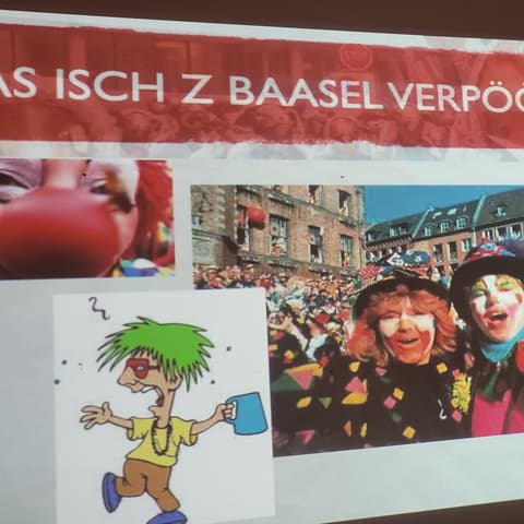 Bytový seminář s Olgou Cieslarovou: snímek prezentace s karnevalovými maskami a nápisem Was isch z Baasel verpöönt?