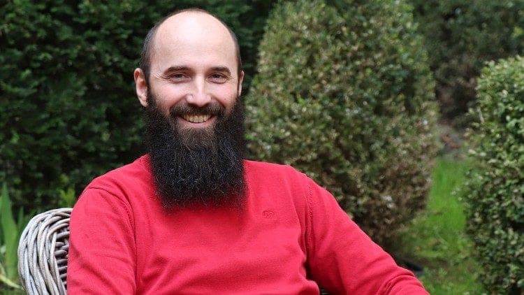 Pavel Pola v červeném svetru na zahradě